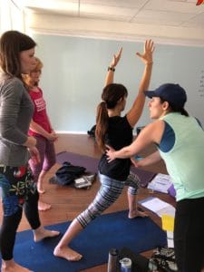 Instructor teaching yoga teacher training students how to make adjustments